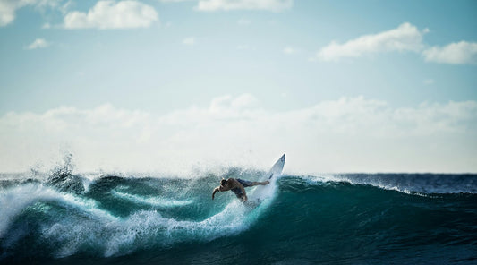 A man surfing in a beautiful wintery landscape, enjoying a Christmas surf trip 2025