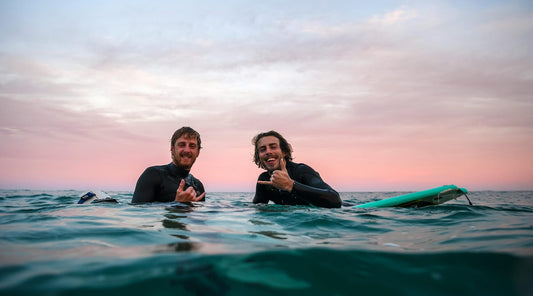 Two surfers posing after enjoying surfing in winter