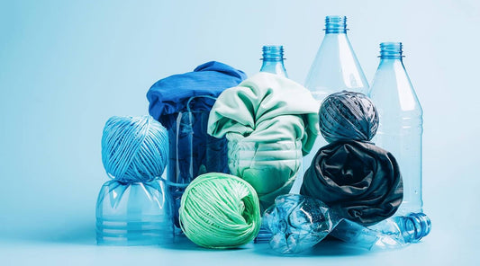 Close-up view of repurposed plastic bottles, colorful yarn skeins, and fabric scraps, highlighting how recycled plastic clothing is revolutionizing the fashion industry