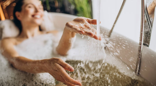 Women relaxing in bath with bubbles, not using the bucket method to save water