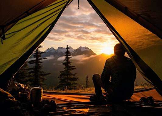 A young traveler enjoys the mountain view while having quick-drying towels for camping with him