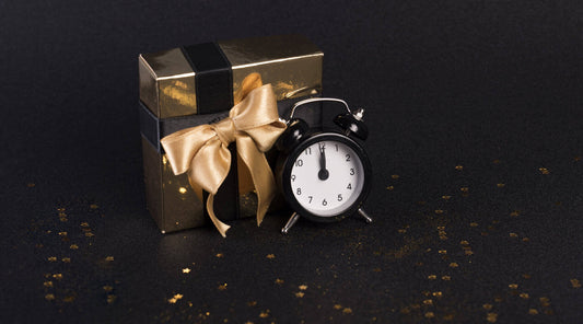 A close-up of a beautifully wrapped gift box with a clock and gold tag